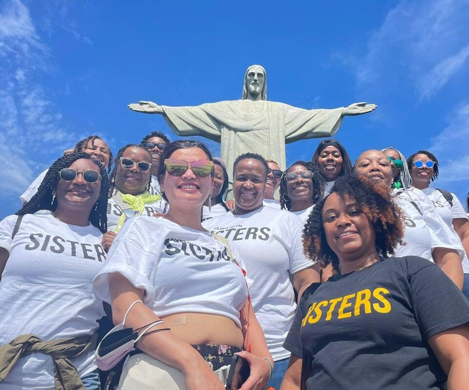 photo of colombian women with fruit standing in front of buildiing
