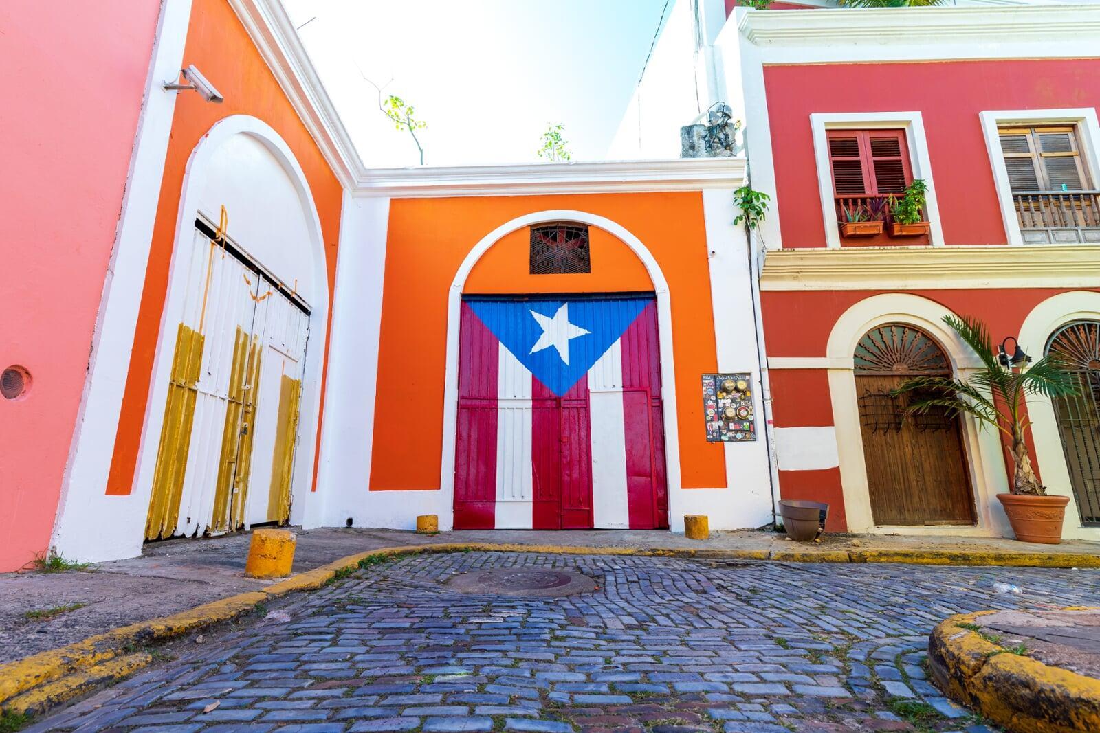 photo of colorful colombian houses with a colombia flag handing over