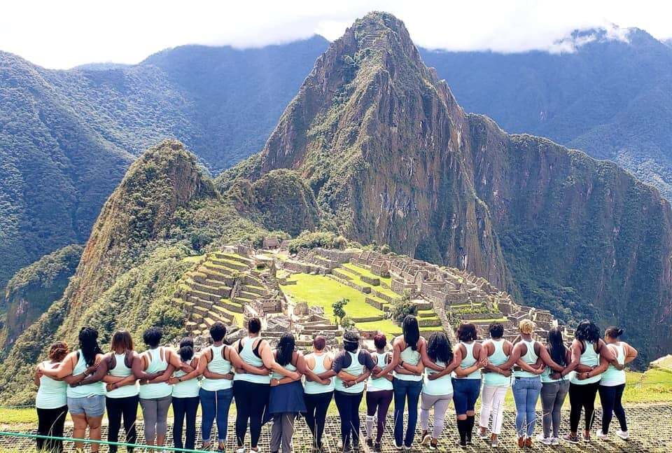 photo of colombian women with fruit standing in front of buildiing