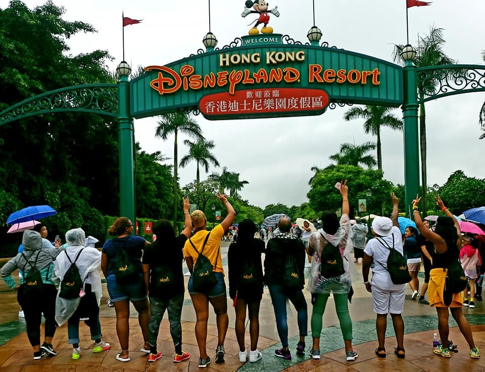 photo of a group of women all wearing gold shirts that say sisters