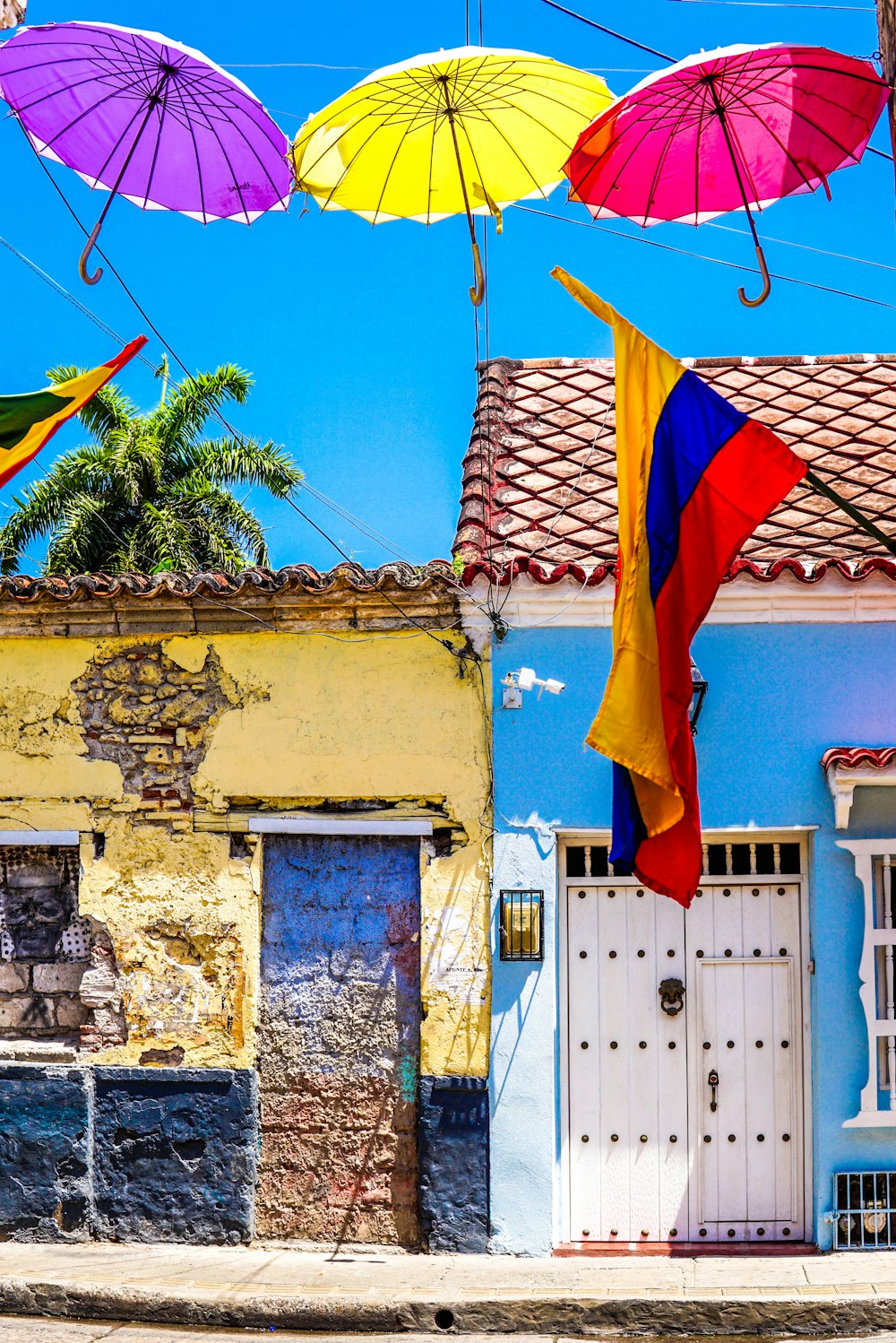 photo of colorful colombian houses with a colombia flag handing over