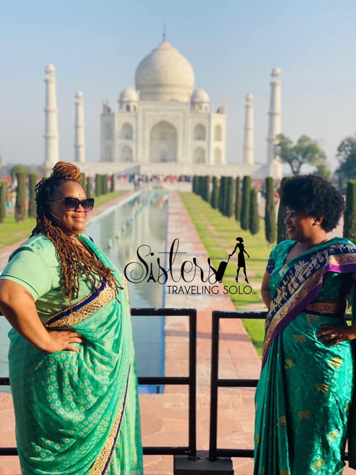 photo of colombian women with fruit standing in front of buildiing